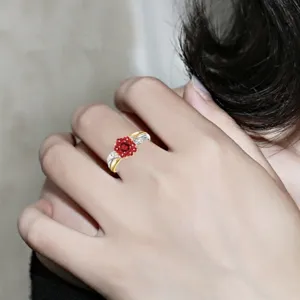 Exquisito anillo floral rojo con diamantes brillantes y banda metálica bicolor.