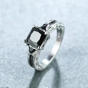 Gros plan sur une bague en zircon noir carré avec un anneau argenté gravé vintage, détail.