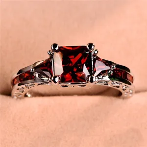 Bague zircon rouge de luxe, pierre principale carrée élégante, détail de bijou argenté fin.