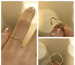 Primo piano dettagliato di un anello quadrato minimalista in oro con uno zircone.