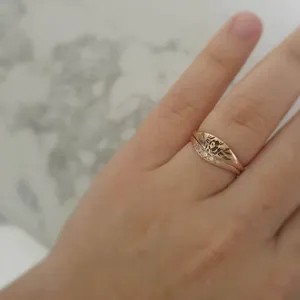 Gros plan de la bague empilée en or rose gravée de fleurs et de l'alliance étincelante.