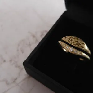 Gros plan détaillé d'une bague dorée gravée florale rétro et d'une bague incurvée.