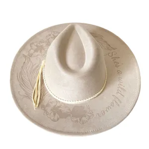 Close-up top view of light grey suede western cowboy hat with floral feather prints.
