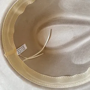 Detailed view of the inner lining and wash label of a classic beige felt fedora hat.