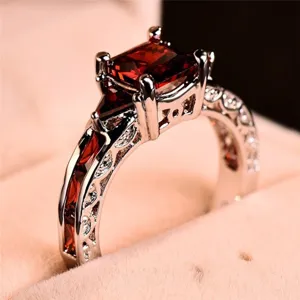 Superbe gros plan d'un luxueux anneau carré en zircon rouge avec des détails argentés.