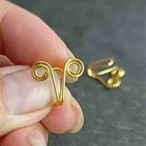 Vista detallada de anillo de nariz falso en forma de U de alambre dorado, joya sin perforación.