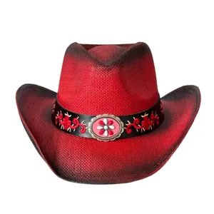 Dettaglio del cappello da cowboy in paglia rossa con ricamo squisito e fibbia metallica centrale.