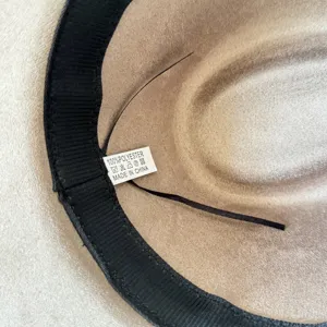 Close-up detail van de hoedbinnenkant met zwarte zweetband en honderd procent polyester label.