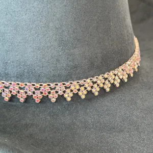 Detailopname van prachtige fonkelende strassketting op donkere sudedoek cowboyhoed.