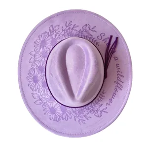 Lavender suede fedora hat with laser engraved daisy and wildflower text details.