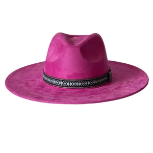 Détails rapprochés du superbe chapeau fedora fuchsia en suédine avec une bande tissée.