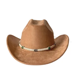 Primo piano di un cappello cowboy in camoscio marrone con fascia intrecciata e perle.