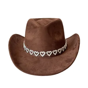Detail view of brown faux suede cowboy hat featuring a sparkling rhinestone heart chain band.