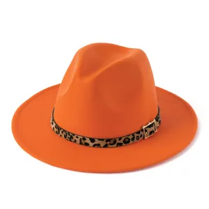 Detalles del sombrero de fieltro naranja con cinturón de leopardo y hebilla dorada brillante.
