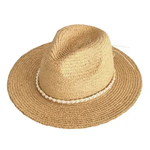 Detailed view of summer straw hat with pearl band, perfect beach sun protection fedora.