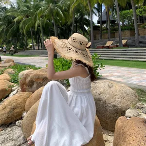 French hollow raffia straw hat detail shot showing wide brim, frayed edge and elegant beach style.