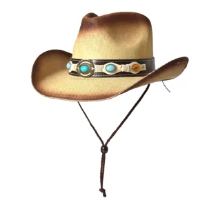Gros plan détaillé du chapeau de cowboy en paille rétro avec son bandeau en cuir orné de pierres.