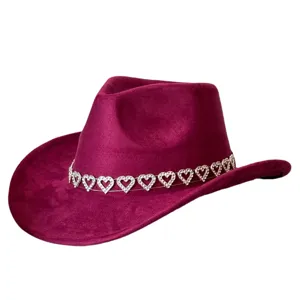 Detailed close-up of a burgundy faux suede cowboy hat featuring a sparkling rhinestone heart band.