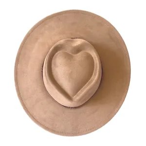 Vue de détail d'un chapeau fedora rétro en suédine avec couronne cœur élégante et bord large.