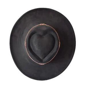 Gros plan détaillé du chapeau noir en faux daim à large bord avec une couronne en cœur.