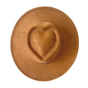 Gros plan détaillé du chapeau fedora marron en suédine à large bord et couronne en cœur.
