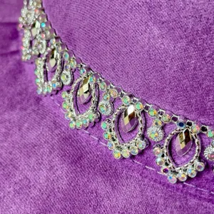 Nahaufnahme Detail der funkelnden Strasskette auf dem violetten Wildleder Westernhut.