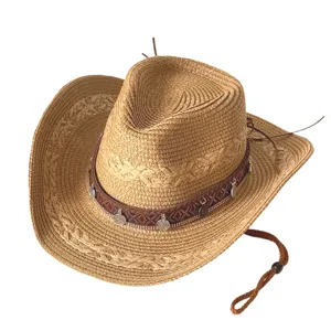Détail du chapeau de cow-boy en paille avec bande à motif ethnique et pendentifs pièces.