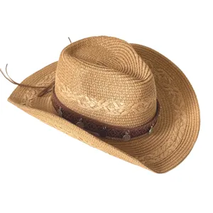 Vue détaillée du chapeau de cowboy en paille ethnique avec un beau bandeau tressé et des pendentifs.