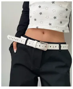 Vue rapprochée d'une élégante ceinture blanche en cuir avec boucle strass et découpes.