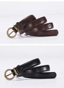Close-up detail of women's slim leather belt with vintage round metal pin buckle.