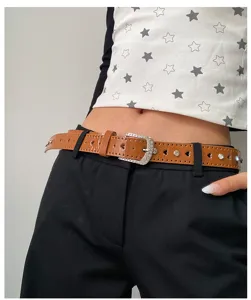 Vue de détail d'une ceinture en cuir marron avec des strass étincelants et des découpes en cœur.