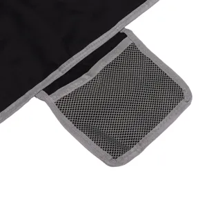 Close-up detail of black travel airplane footrest mesh pocket with gray fabric trim.