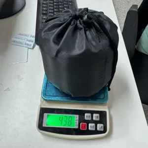 Detailed view of black travel neck pillow storage bag on scale, lightweight portable design.