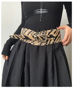 Detailed view of the wide zebra print western style studded waist belt with metal buckle.