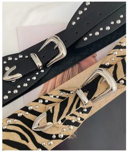 Western style wide belt detail featuring metal buckle, rivets, black and zebra patterns.