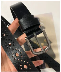 Close-up of black leather belt featuring delicate hollow patterns and durable pin buckle.