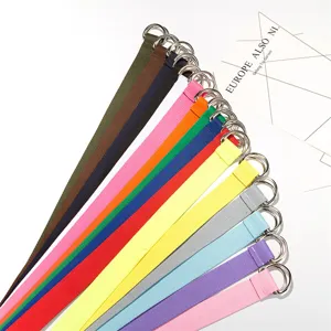 Primo piano di cinture in tela multicolore con robusti anelli a D doppi in metallo e tonalità.