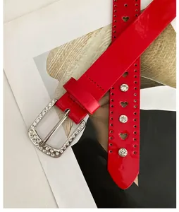 Ceinture en cuir verni rouge avec boucle strass et découpes en cœur mode élégante