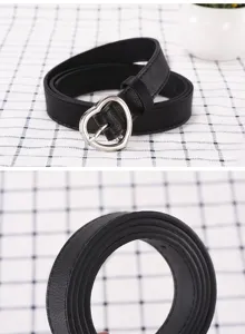 Close-up detail shot of the black leather belt with silver heart buckle and edge texture.