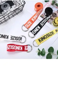 Canvas belt detail showcasing double D-ring metal buckle and stylish letter print pattern.
