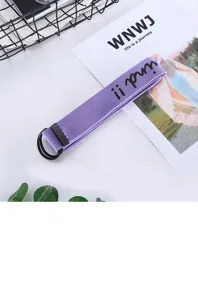 Primo piano della cintura in tela viola con doppio anello a D, design intrecciato casual.