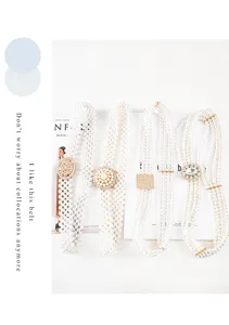 Detail view of elegant pearl belt with sparkling rhinestones, perfect for dresses and coats.