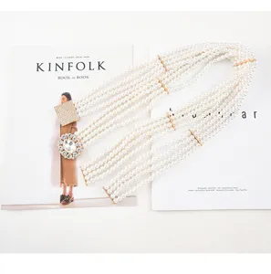 Detailed view of multi-strand pearl stretch waist belt with sparkling rhinestone buckle