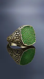 Close-up detail van de prachtige retro heren zegelring met groene stenen en graveren.