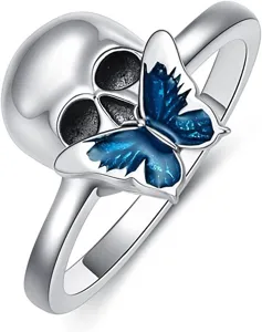 Detailed close-up of a stylish gothic silver skull ring featuring a vibrant blue enameled butterfly.
