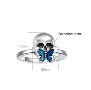 Silver skull ring with blue butterfly and oxidation tech for punk gothic style jewelry.
