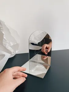 Detailed view of the modern minimalist arch mirror and stylish desktop bookend with art.