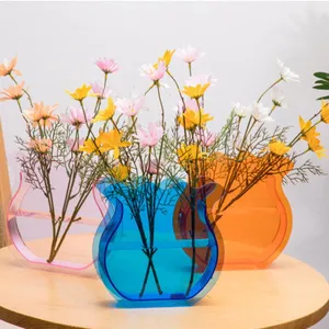 Acrylic vase detail showing transparent colorful containers with beautiful flowers