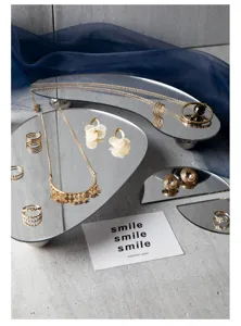 Detailed shot of irregular mirror jewelry tray with elegant gold accessories for display setup.