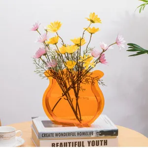 Acrylic decorative flower vase with artificial daisy bouquet for modern home tabletop styling.